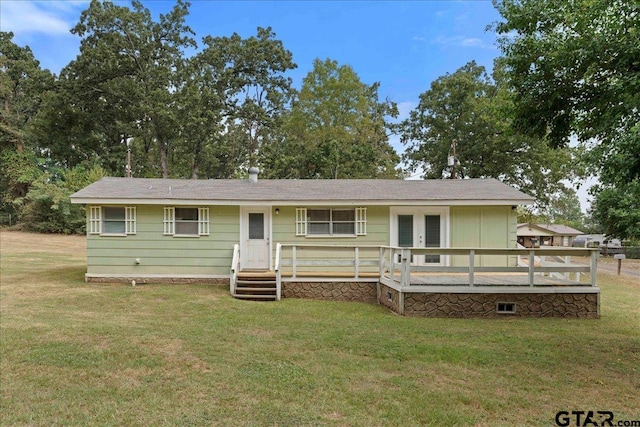 ranch-style home with a deck and a front lawn