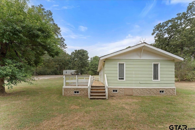 view of side of home featuring a yard and a deck