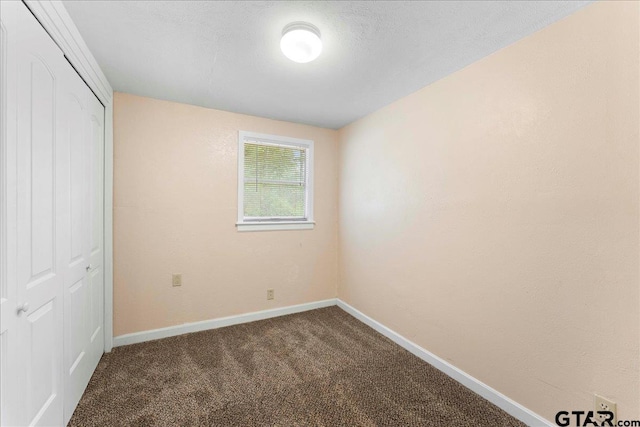 unfurnished bedroom with carpet, a textured ceiling, and a closet