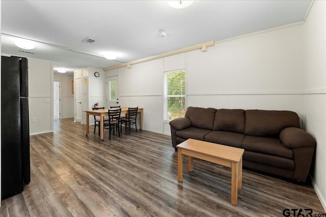 living room with hardwood / wood-style floors and ornamental molding