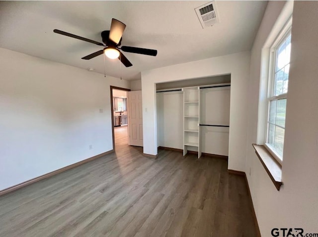 unfurnished bedroom with ceiling fan, a closet, and wood-type flooring