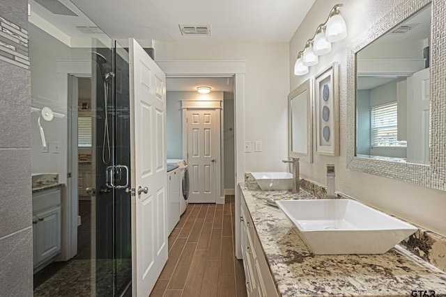 bathroom with walk in shower, wood-type flooring, vanity, and independent washer and dryer