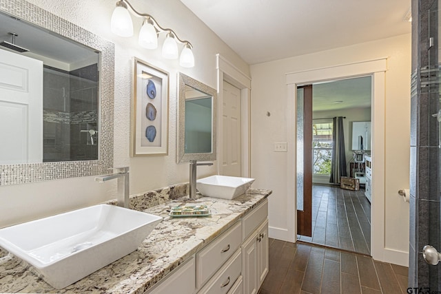 bathroom featuring hardwood / wood-style floors, vanity, and a shower