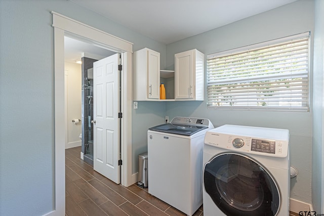 laundry area with dark wood-type flooring, cabinets, and washer and dryer