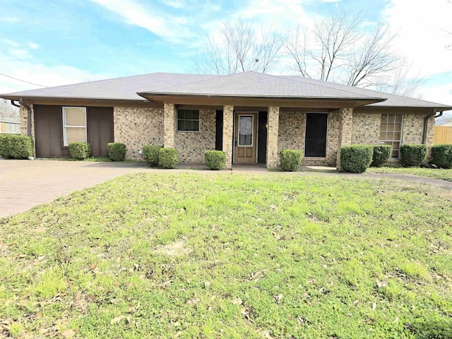 ranch-style house featuring a front lawn, brick siding, and roof with shingles