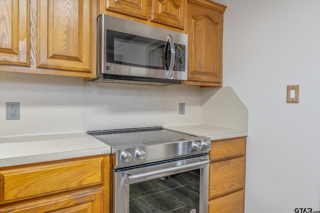 504 Susie St, Chandler, TX 75758 - kitchen featuring appliances with stainless steel finishes, light countertops, and brown cabinets
