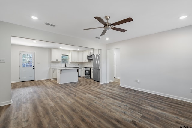 kitchen featuring ceiling fan, appliances with stainless steel finishes, dark hardwood / wood-style floors, a center island, and white cabinets