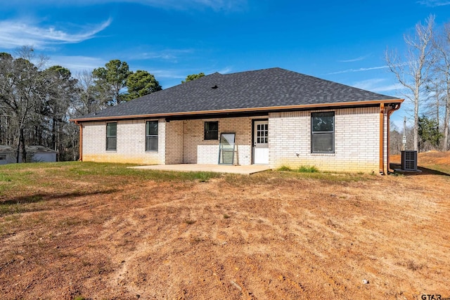 rear view of property with central air condition unit, a patio area, and a lawn