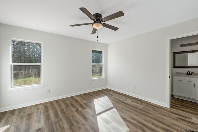 empty room with dark hardwood / wood-style flooring, ceiling fan, and a healthy amount of sunlight