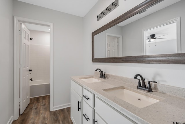 bathroom with vanity, hardwood / wood-style floors, ceiling fan, and bathing tub / shower combination