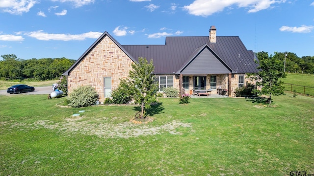 4180 N Smith Rd, Rockwall, TX 75087 - back of house with a chimney, stone siding, a patio area, and a metal roof