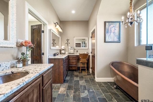 4180 N Smith Rd, Rockwall, TX 75087 - full bathroom featuring two vanities, a freestanding tub, stone tile flooring, and recessed lighting