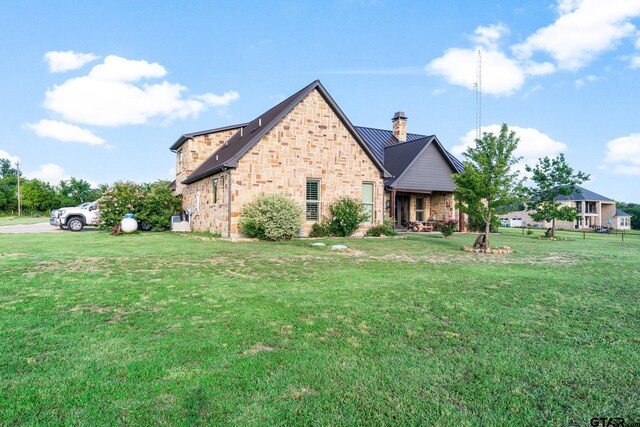 4180 N Smith Rd, Rockwall, TX 75087 - back of house with a chimney, a yard, brick siding, a metal roof, and a standing seam roof