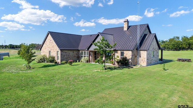 4180 N Smith Rd, Rockwall, TX 75087 - view of front of house featuring a front lawn, a chimney, a standing seam roof, a metal roof, and brick siding