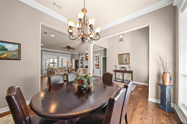 dining room featuring dark wood-type flooring, crown molding, and ceiling fan with notable chandelier