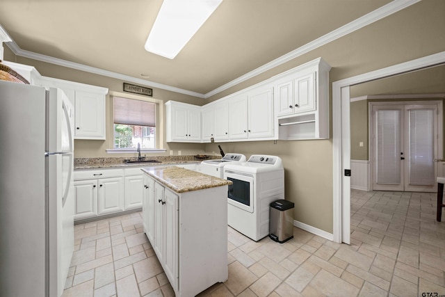 kitchen featuring sink, a center island, white cabinets, washer and dryer, and white fridge