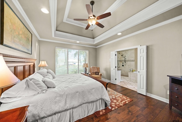 bedroom with ceiling fan, a raised ceiling, crown molding, dark wood-type flooring, and connected bathroom