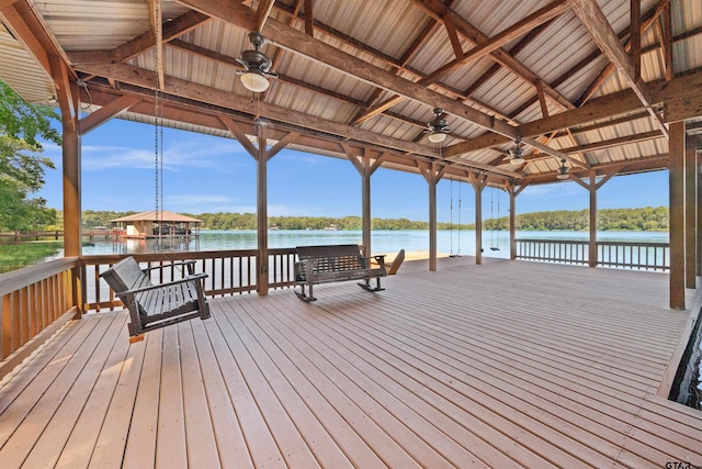 wooden deck featuring ceiling fan, a gazebo, and a water view