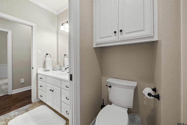 bathroom with hardwood / wood-style floors, vanity, toilet, and ornamental molding