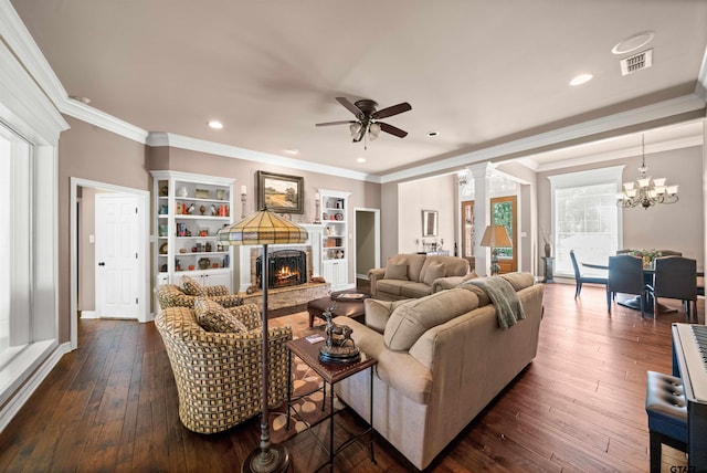 living room with ornamental molding, dark hardwood / wood-style floors, and ceiling fan with notable chandelier