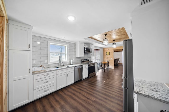 kitchen with white cabinetry, sink, light stone counters, and stainless steel appliances