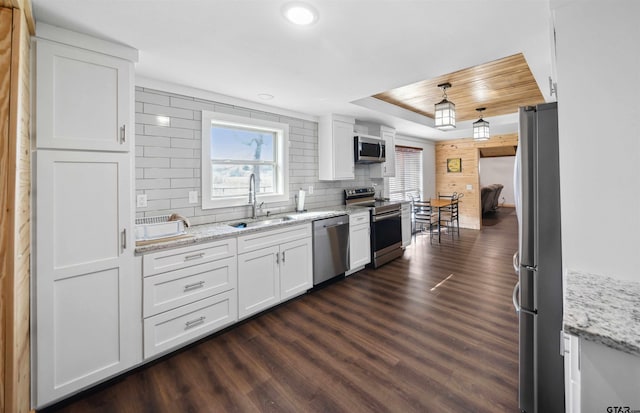 kitchen with backsplash, stainless steel appliances, sink, and white cabinets