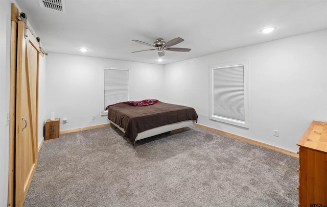 bedroom with a barn door, carpet, and ceiling fan