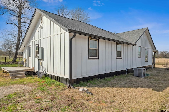 view of side of home featuring central AC unit and a lawn