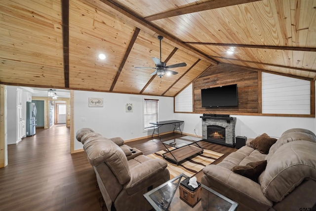 living room with ceiling fan, lofted ceiling with beams, dark hardwood / wood-style flooring, a stone fireplace, and wooden ceiling