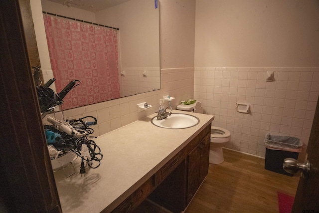 bathroom featuring hardwood / wood-style flooring, tile walls, toilet, and vanity