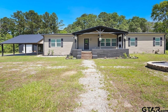 view of front of property with covered porch, ceiling fan, a carport, and a front yard