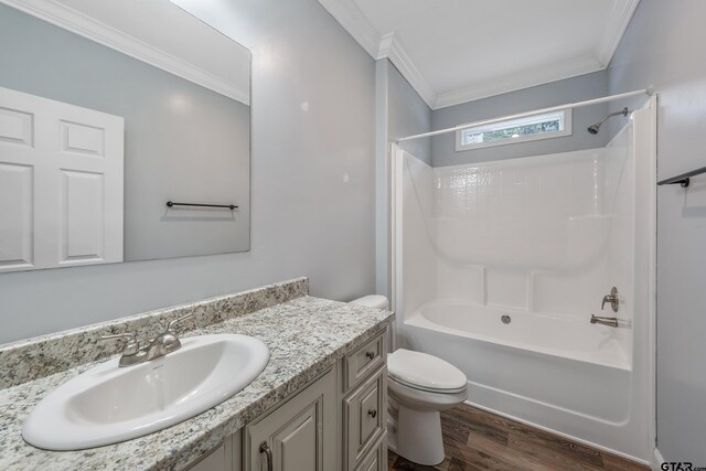 full bathroom featuring toilet, wood finished floors, vanity, crown molding, and washtub / shower combination