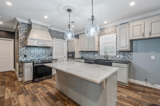 kitchen featuring crown molding, custom exhaust hood, stainless steel electric range, and a sink