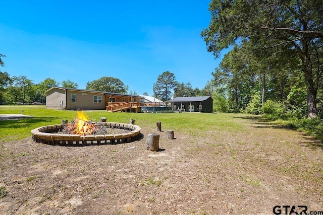 view of yard with a deck and a fire pit