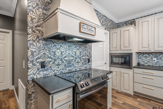 kitchen with crown molding, custom exhaust hood, stainless steel range with electric stovetop, and built in microwave