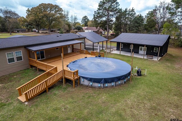 view of pool featuring a yard, stairway, a wooden deck, and a covered pool