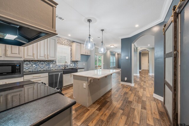 kitchen with a sink, ornamental molding, visible vents, dishwasher, and built in microwave