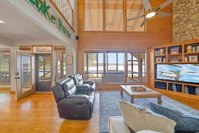 living room featuring a wealth of natural light, beamed ceiling, and high vaulted ceiling