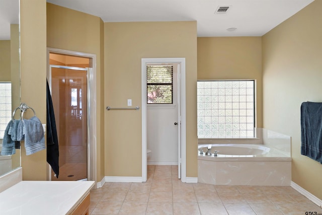 bathroom with tile patterned flooring, toilet, and plus walk in shower