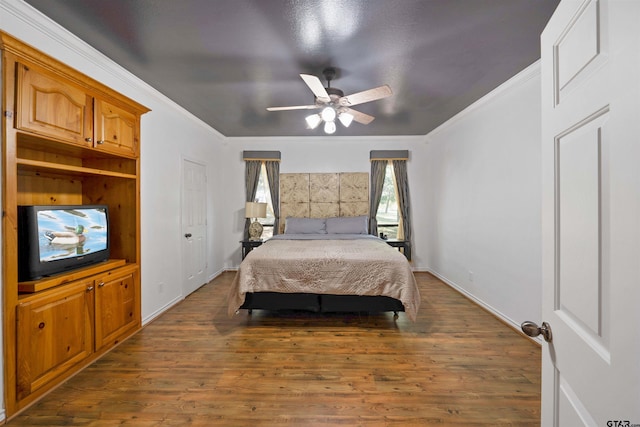 bedroom featuring dark hardwood / wood-style floors, ceiling fan, and crown molding