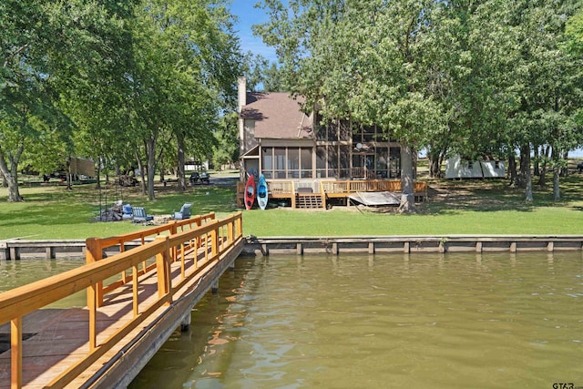 dock area with a lawn and a deck with water view