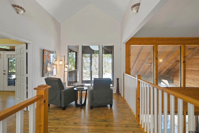 living room with beamed ceiling, hardwood / wood-style flooring, and high vaulted ceiling