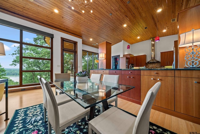 dining space featuring light wood-type flooring and wooden ceiling