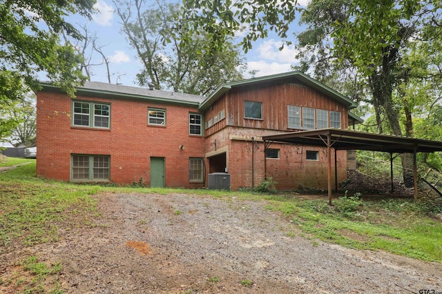 rear view of house with cooling unit and a carport