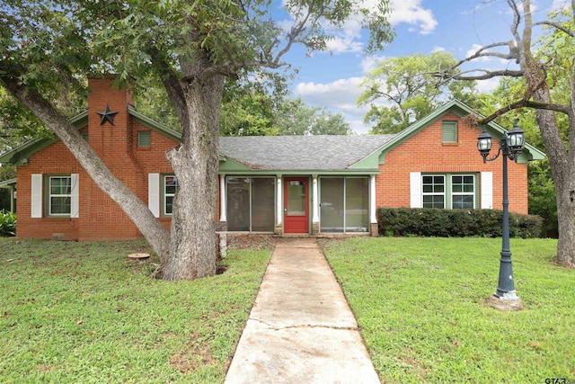 view of front of property with a sunroom and a front yard