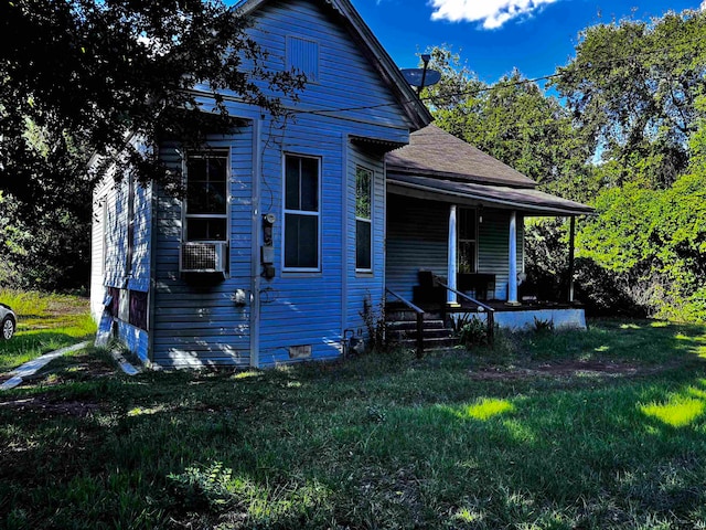 view of side of property featuring a yard and covered porch