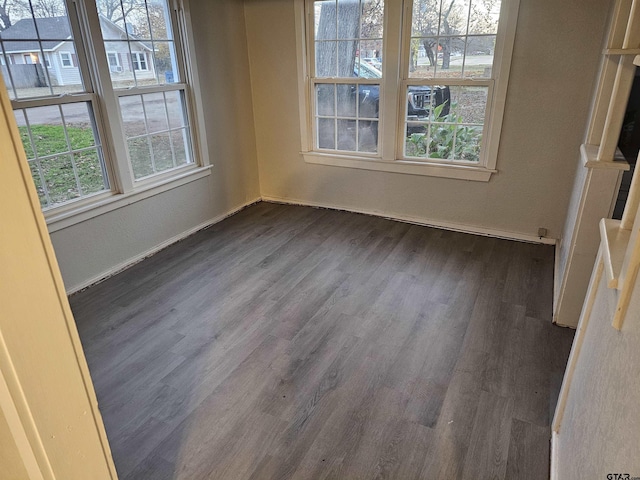 unfurnished dining area featuring a healthy amount of sunlight and dark hardwood / wood-style floors