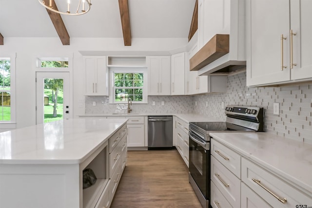 kitchen with beamed ceiling, decorative backsplash, stainless steel appliances, and white cabinets