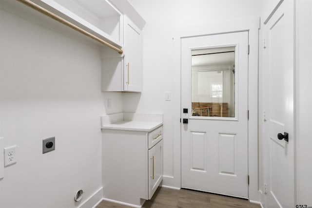 laundry area with hookup for an electric dryer, dark hardwood / wood-style flooring, and cabinets