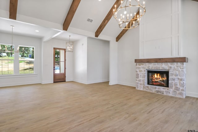 unfurnished living room with vaulted ceiling with beams, a fireplace, and light hardwood / wood-style floors